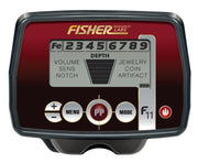 A detailed close-up of the Fisher Labs F11 metal detector's control panel, featuring its red and black digital display with settings for volume, sensitivity, notch, depth, and target categories like jewelry, coin, and artifact, along with various control buttons.