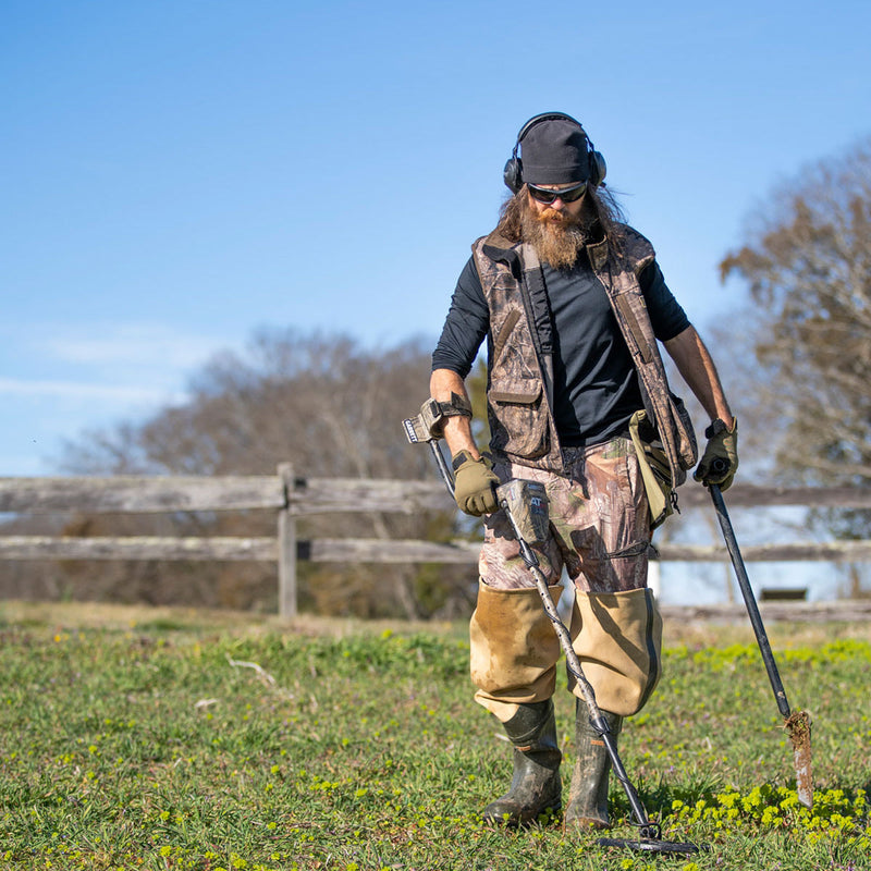 Detectorist hunting a field with the Garrett AT Max Jase Robertson edition