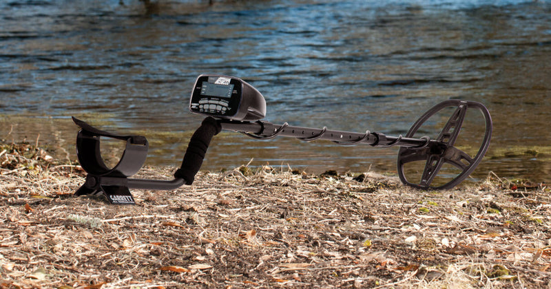Garrett AT Pro metal detector on a riverbank ready for fresh water hunting