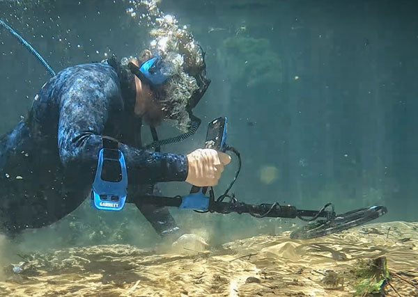 Diver using a Garrett Vortex waterproof metal detector underwater